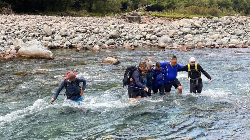 Linking arms, crossing the Deception River over Goat Pass. |  <i>Adventure South NZ</i>