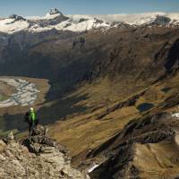Trekker on Buchanan peak with Mount Aspiring behind, walking above Matukituki valley, near Lake Wanaka | Colin Monteath